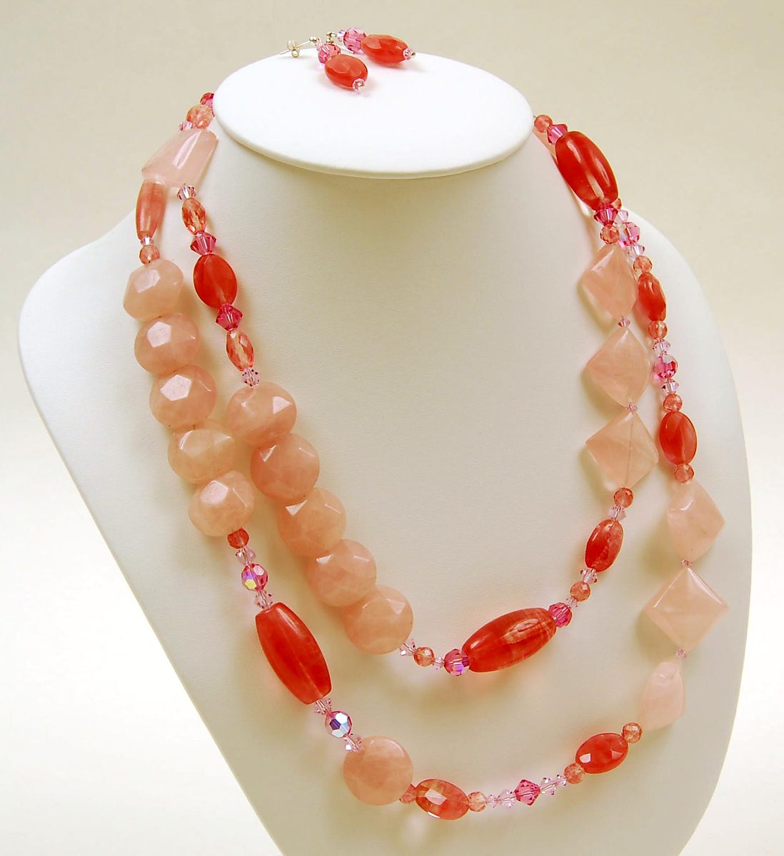 Two-strand rose quartz and pink crystal necklace with earrings on a white bust